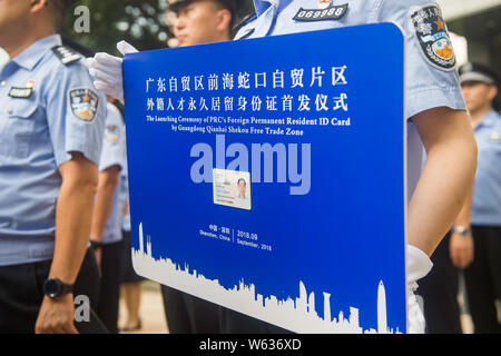 Les agents de police afficher la carte d'identité de l'homme - Zhang Wei, qui est la première carte d'identité de résident permanent étranger délivré par le Guangdong Qi Banque D'Images