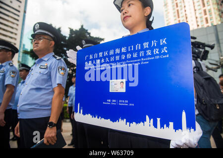 Les agents de police afficher la carte d'identité de l'homme - Zhang Wei, qui est la première carte d'identité de résident permanent étranger délivré par le Guangdong Qi Banque D'Images