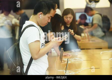 Un client chinois essaie l'iPhone et les smartphones XS XS Max au West Lake Hangzhou phare Apple Store en ville, est de la Chine, de la province de Zhejiang Banque D'Images