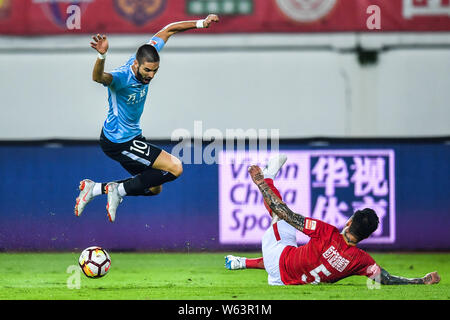 Joueur de football professionnel belge Yannick Ferreira Carrasco, gauche, de Dalian Yifang Zhang Linpeng défis de Guangzhou Evergrande Taobao dans thei Banque D'Images