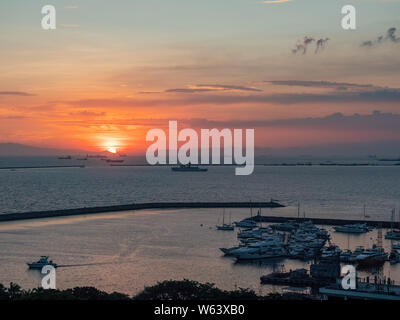 Coucher du soleil à la baie de Manille avec Yacht Club de Manille à l'avant-plan. Banque D'Images
