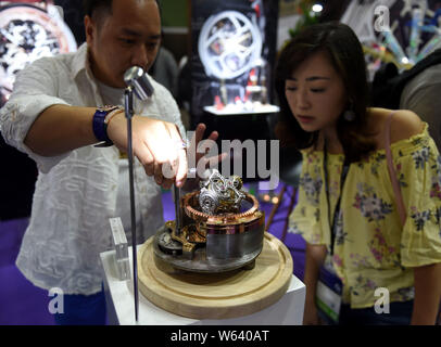 Un travailleur présente un mouvement mécanique à un visiteur au cours de la Hong Kong Watch & Clock Fair 2018 à Hong Kong, Chine, le 4 septembre 2018. Banque D'Images