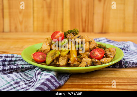 Faire revenir le poulet, les courgettes et le brocoli sur fond de bois Banque D'Images