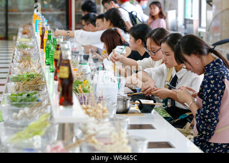 Les élèves manger bande de potée, littéralement "hot pot", rotation à une cantine de l'Université Xi'an de la finance et de l'économie dans la ville de Xi'an, dans les ch Banque D'Images