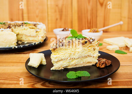 Gâteau au miel avec du fromage cottage, des oranges et des noix, décoré avec du chocolat blanc Banque D'Images