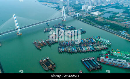 Les bateaux de pêche sont à quai dans un port en préparation de typhon Barijat, le 23e typhon de l'année, dans la ville de Haikou, Chine du sud, province de Hainan Banque D'Images