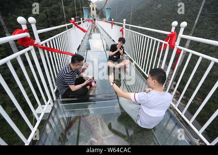 Des touristes posent pour des photos sur les 60 étages de haut pont suspendu à fond de verre à l'Taihuyuan dans la zone panoramique de Lin'an district, Hangzhou city, C'est Banque D'Images