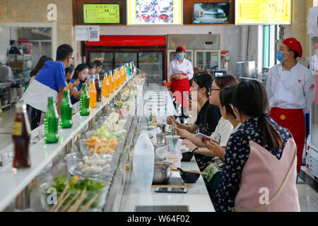 Les élèves manger bande de potée, littéralement "hot pot", rotation à une cantine de l'Université Xi'an de la finance et de l'économie dans la ville de Xi'an, dans les ch Banque D'Images