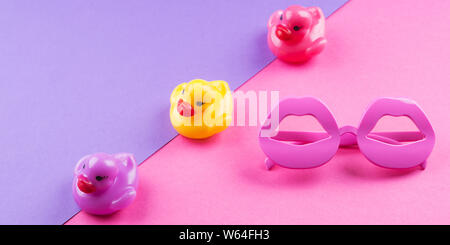 Funky coloré de l'été mise à plat avec les articles drôle - canards en caoutchouc, lunettes de forme de lèvre. Rose et violet fond duotone. Banque D'Images