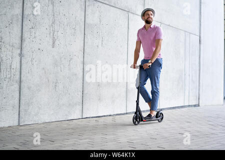 Happy man riding scooter de coup Banque D'Images