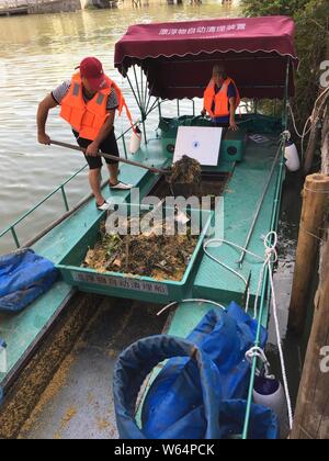 Un travailleur chinois utilise un bateau équipé d'un nouveau dispositif de collecte des déchets dans une rivière en Xujiazhan, village du comté de Yingze District, Shanghai, Chine de l'Est' Banque D'Images