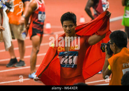 Su Bingtian de Chine pose avec le drapeau national chinois pour célébrer après avoir remporté le 100 m de la finale de la compétition d'athlétisme au cours de l'Asi 2018 Banque D'Images