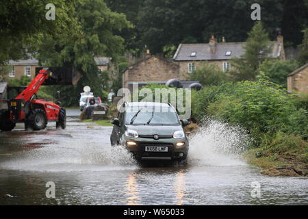 Une voiture roulant à travers l'eau d'inondation dans la région de Yorkshire, après certaines parties de la région avait 82,2 millions jusqu'à mm de pluie en 24 heures mardi. Banque D'Images