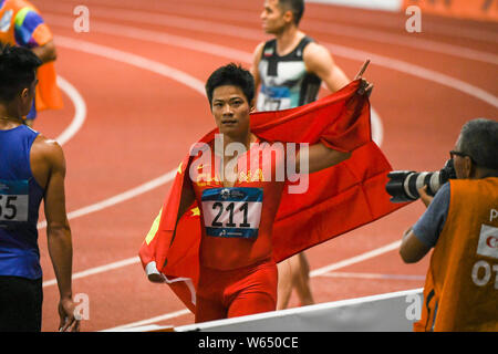 Su Bingtian de Chine pose avec le drapeau national chinois pour célébrer après avoir remporté le 100 m de la finale de la compétition d'athlétisme au cours de l'Asi 2018 Banque D'Images