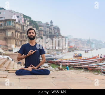 Professeur de Yoga méditation Ayush par le Gange à Varanasi au lever du soleil. Banque D'Images