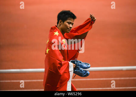 Su Bingtian de Chine pose avec le drapeau national chinois pour célébrer après avoir remporté le 100 m de la finale de la compétition d'athlétisme au cours de l'Asi 2018 Banque D'Images