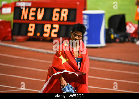 Su Bingtian de Chine pose avec le drapeau national chinois pour célébrer après avoir remporté le 100 m de la finale de la compétition d'athlétisme au cours de l'Asi 2018 Banque D'Images