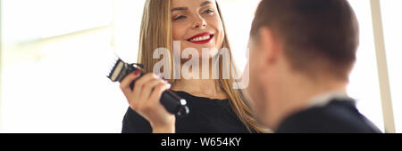 Smiling coiffure à l'aide de rasoir électrique au Client Banque D'Images