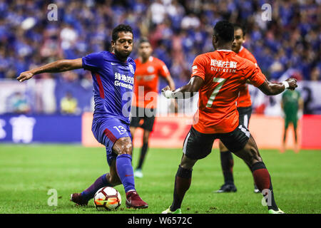 Joueur de football colombien Fredy Guarin, gauche, du Groenland Shanghai Shenhua passe le ballon contre un joueur de football Kenyan Ayub Masika de Pékin Renh Banque D'Images