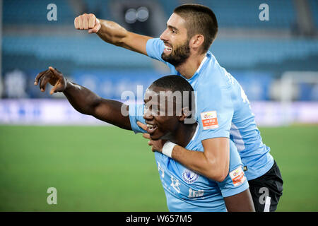 Joueur de football zimbabwéen Nyasha Mushekwi de Dalian Yifang, abaisser, célèbre avec son coéquipier joueur belge de football Yannick Ferreira Carrasco après Banque D'Images