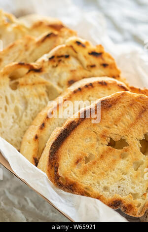 Tranches de pain baguette grillées sur fond blanc close up. Croûton de pain grillé,. Vue d'en haut Banque D'Images