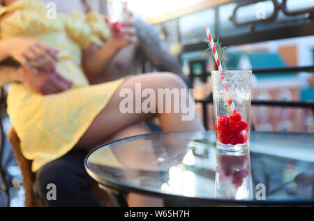 Couple heureux en amour avec limonade rafraîchissante l'été potable rasberry sur un balcon Banque D'Images