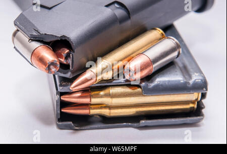 Deux magazines chargés, l'un pour un pistolet 9 mm et l'autre pour un fusil de calibre 223 sur un fond blanc Banque D'Images