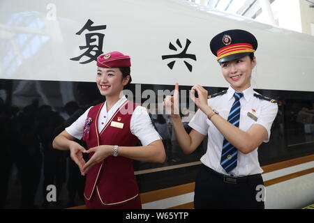 Les accompagnateurs de train chinois posent devant un 'haut-débit' Fuxing bullet train pour fonctionner sur ferroviaire interurbain Beijing-Tianjin comme la vitesse du train seront i Banque D'Images