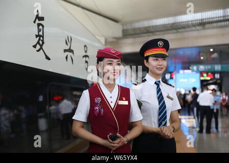 Les accompagnateurs de train chinois posent devant un 'haut-débit' Fuxing bullet train pour fonctionner sur ferroviaire interurbain Beijing-Tianjin comme la vitesse du train seront i Banque D'Images