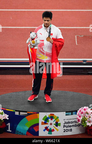 Su Bingtian de Chine pose avec le drapeau national chinois pour célébrer après avoir remporté le 100 m de la finale de la compétition d'athlétisme au cours de l'Asi 2018 Banque D'Images