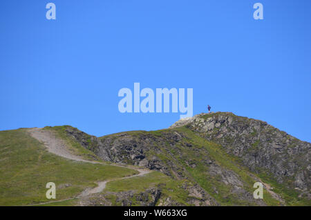 Homme seul debout sur le sommet de la tête de l'Hopegill Wainwright Parc National de Lake District, Cumbria, England, UK. Banque D'Images