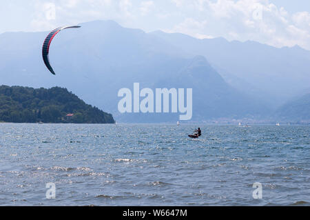 Le lac de Côme, Italie - 21 juillet 2019. Le sport de l'eau : kitesurfer surf le vent sur les vagues sur journée d'été ensoleillée près de la ville de Colico, en Italie. Pomonto Banque D'Images