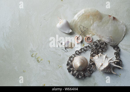 Collection La mer sur fond de marbre gris. Coquillage et nacre earrings. Bijoux d'été. Chaîne en métal , mère-de-pearl shells Banque D'Images