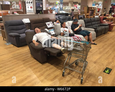 Les résidents locaux chinois le sommeil et le repos sur les canapés dans un magasin de meubles et d'accessoires japonais accueil détaillant Nitori à Wuhan, Chine centrale's Hube Banque D'Images