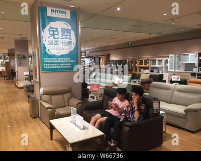 Les résidents locaux chinois le sommeil et le repos sur les canapés dans un magasin de meubles et d'accessoires japonais accueil détaillant Nitori à Wuhan, Chine centrale's Hube Banque D'Images