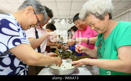 --FILE--Personnes âgées Personnes locales faire des boulettes de riz ou Zongzi pour célébrer le prochain Festival du bateau-dragon, ou Duanwu Festival, à une communauté de Beiji Banque D'Images