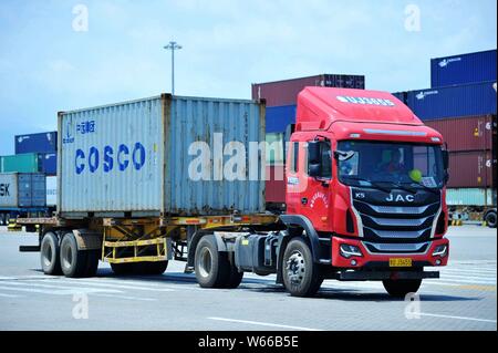 --FILE--un camion transporte un récipient de COSCO Voyage être expédiés à l'étranger, sur un quai du port de Qingdao en Qingdao city, Shandong en Chine de l'Est Banque D'Images