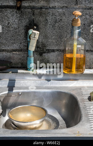 Évier Avec robinet et détergent pour lave-vaisselle à l'extérieur cuisine. Lavabo avec robinet et du liquide vaisselle dans la bouteille en plastique. Banque D'Images