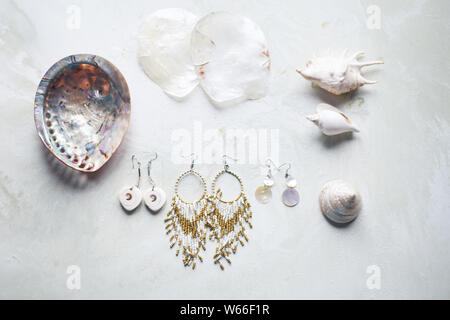 Collection La mer sur fond de marbre gris. Coquillage et nacre earrings. Bijoux d'été. Plaquettes en nacre et perle boucles d'oreille. Banque D'Images