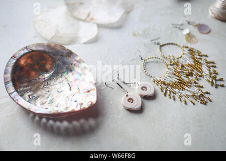 Collection La mer sur fond de marbre gris. Coquillage et nacre earrings. Bijoux d'été. Banque D'Images