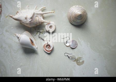 Collection La mer sur fond de marbre gris. Coquillage et nacre earrings. Bijoux d'été. Banque D'Images