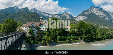 Reichenau, GR / Suisse - 30. Juillet 2019 : Reichenau Château et pont sur le Rhin, avec les Alpes Suisses dans l'arrière-plan Banque D'Images