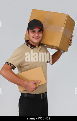 Delivery man carrying parcels and smiling Stock Photo