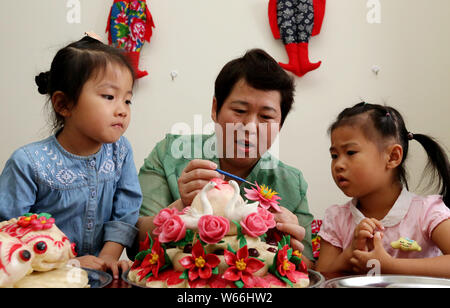 Patrimoine culturel immatériel successeur Wang Xin, centre, apprend aux enfants à faire des petits pains à la vapeur à son domicile à Zaozhuang City, Shandong en Chine de l'est pr Banque D'Images