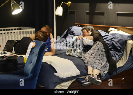 Les résidents locaux chinois le sommeil et le repos sur un lit dans un magasin de meubles d'IKEA pour fuir la chaleur de la ville de Nanjing, Jiangsu province de Chine orientale, 11 Jui Banque D'Images