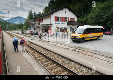 Versam, GR / Suisse - 30. Juillet 2019 : Le bus public attend à la gare de Versam pour le train de passer alors que de nombreux touristes à pied autour de Banque D'Images