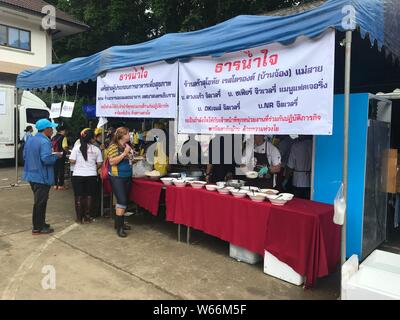 Les bénévoles préparent les aliments et distribuer des fournitures à un centre de support temporaire dans la province de Chiang Rai, Thaïlande, 10 juillet 2018. Les 12 garçons et leur fo Banque D'Images