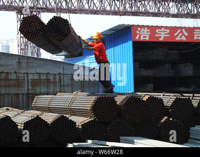 --FILE--Un travailleur chinois dirige une grue pour soulever l'exportation de produits en acier à un marché de l'acier dans la ville de Yichang, province du Hubei en Chine centrale, 11 S Banque D'Images