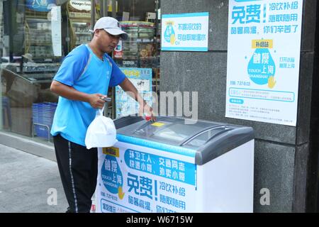 Un homme obtient la livraison de nourriture de boissons sans surveillance un amour 'congélateur' qui fournit gratuitement l'eau et de glace pour les courriers, les gars de livraison de nourriture, la police de la circulation Banque D'Images