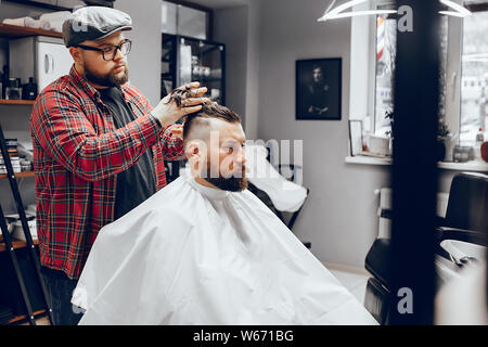 Homme assis dans un élégant salon de coiffure Banque D'Images